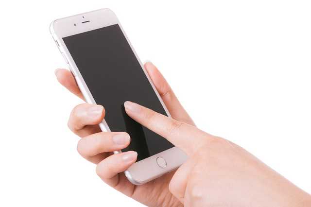大宮でiPhone修理を承る株式会社エムズ-iPhoneを操作している写真-